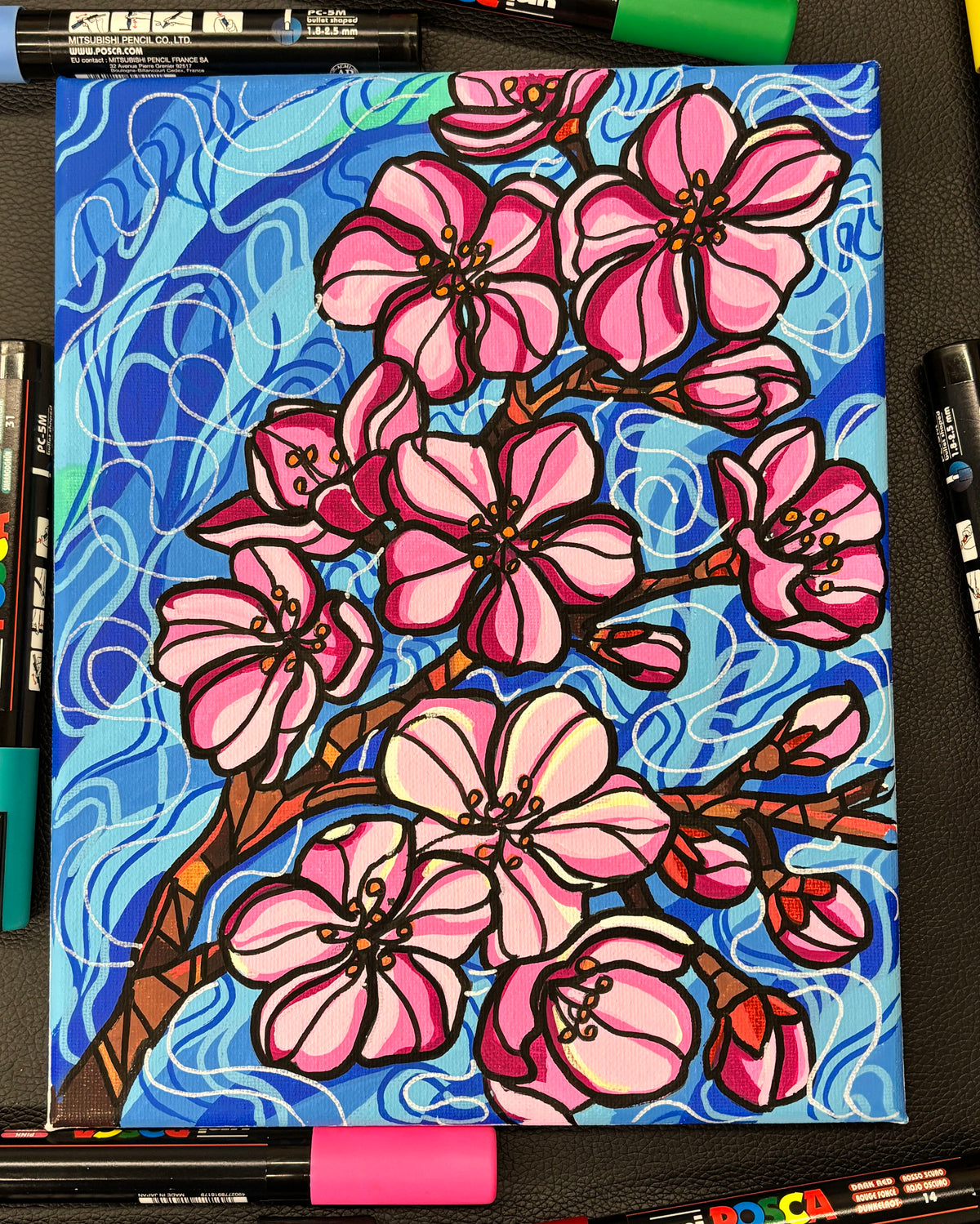 Colorful illustration of pink flowers on a blue background, surrounded by art supplies.
